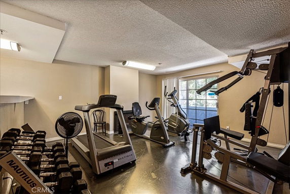 Indoor gym area with exercise equipment including a treadmill, stationary bikes, and weight machines.