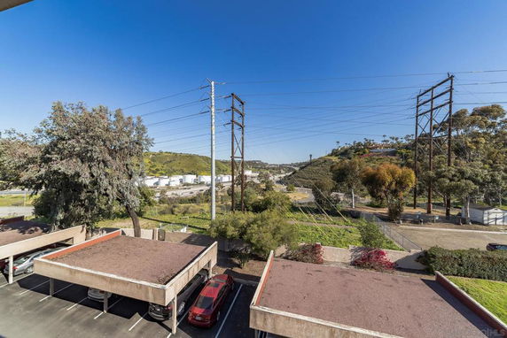 View of surrounding area with hills, trees, and utility lines.