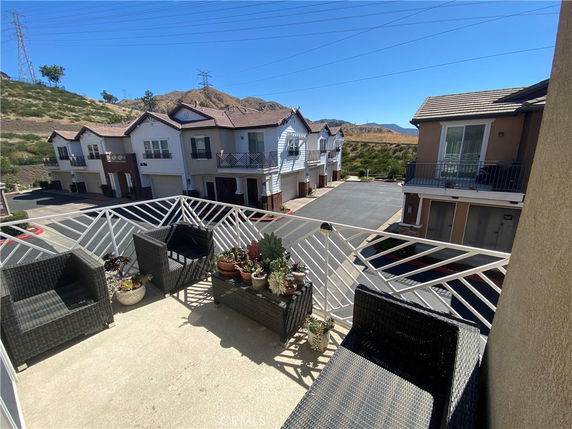 View from a balcony overlooking a row of townhouses and surrounding hills.