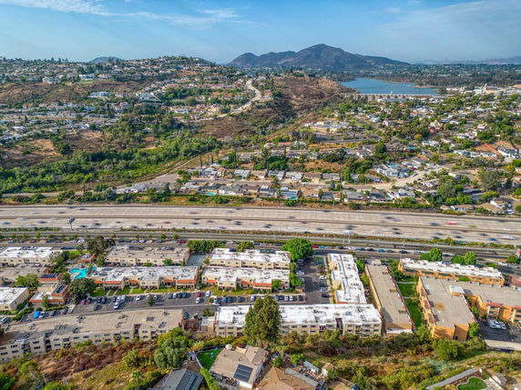 Aerial panoramic view of residential area with roads and hills in the background.