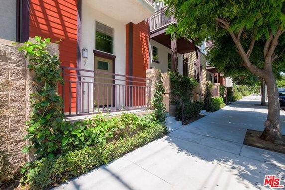 Front view of a modern townhouse with a small front patio and plants.
