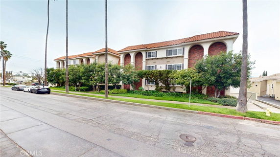 Front view of a building with red-tiled roof and arched windows.