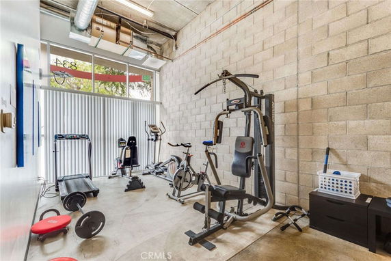 Indoor gym area with exercise equipment including a treadmill and weight machine.