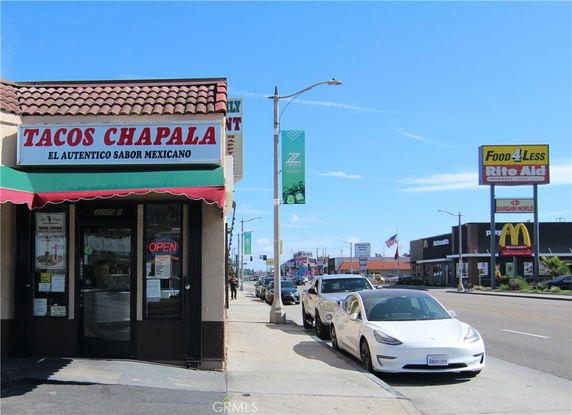 Front view of a taco restaurant with signage on a street.