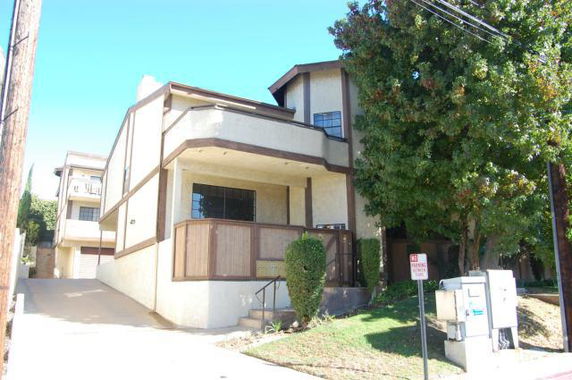 Front view of a multi-story building with a balcony.