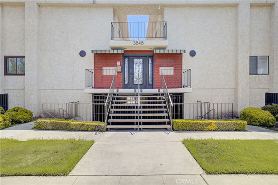 Front view of a building with a central staircase leading to an entrance door.