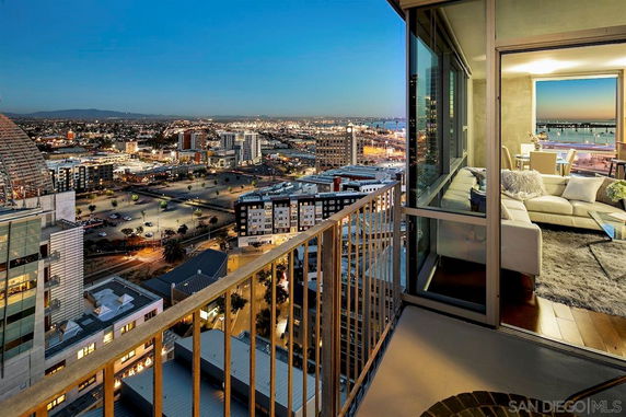Panoramic view of a cityscape from a high vantage point with evening lights visible.