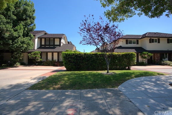 Front view of two two-story houses with garages and driveways.