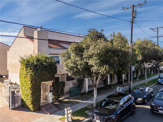 Front view of a multi-story residential building with a gated entrance.