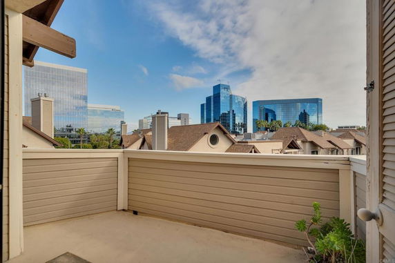 View from a balcony overlooking city buildings and rooftops.