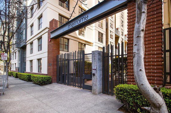 Front view of a multi-story building with a gated entrance.