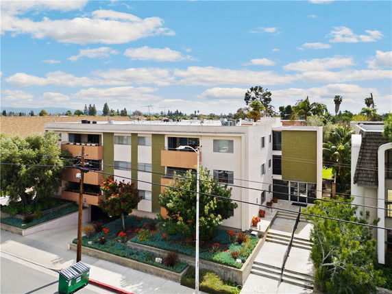 Front view of a multi-story apartment building with a landscaped entrance.