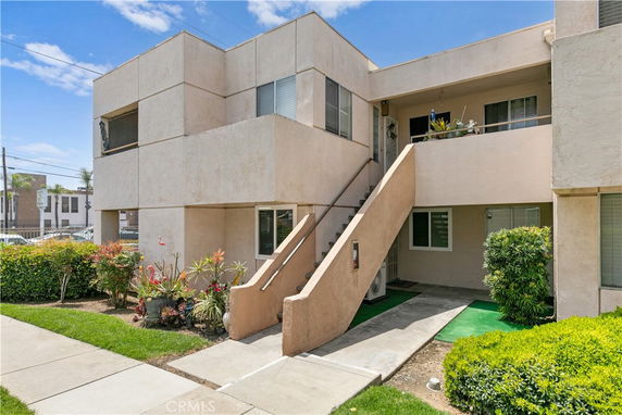 Front view of a two-story apartment building with external stairs.