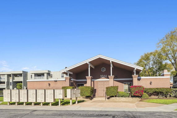 Front view of a single-story building with a brown facade and gabled roof.