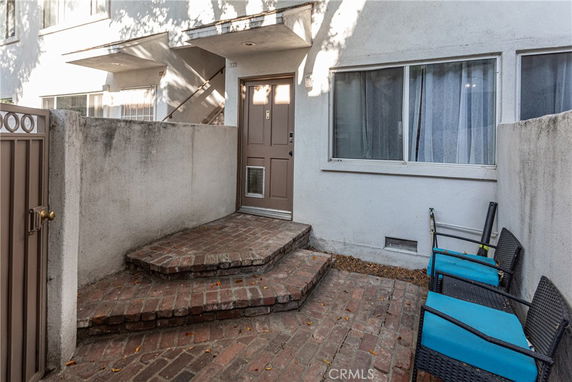 Front view of a small entryway with brick steps leading to a door.