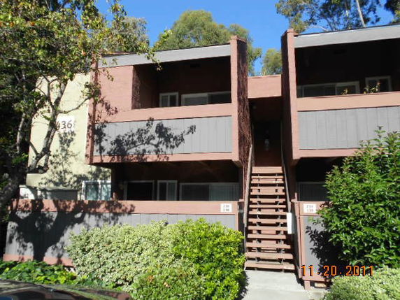 Front view of a two-story apartment building with external staircase.