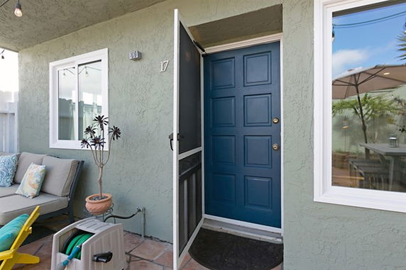 Front view of a house with a blue door and green exterior walls.