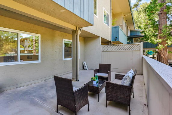 Outdoor patio area with seating next to a multi-story building.