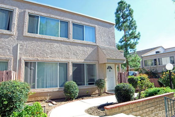 Front view of a two-story house with large windows.
