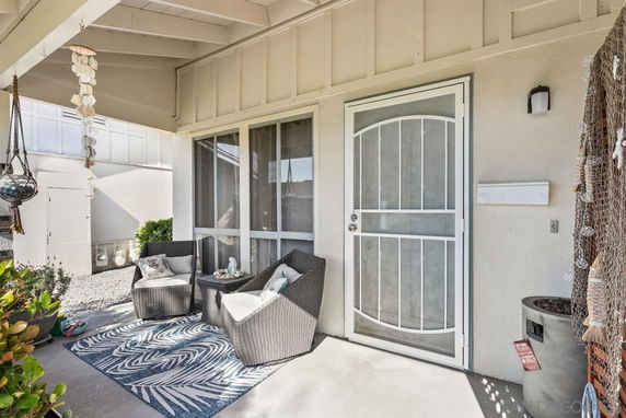 Front view of a house entrance with seating area and decorative elements.