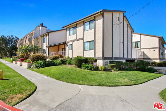 Front view of a two-story building with a walkway and landscaped exterior.