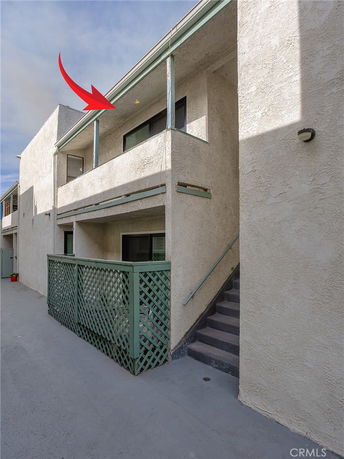 Front view of a two-story building with balconies and exterior stairs.