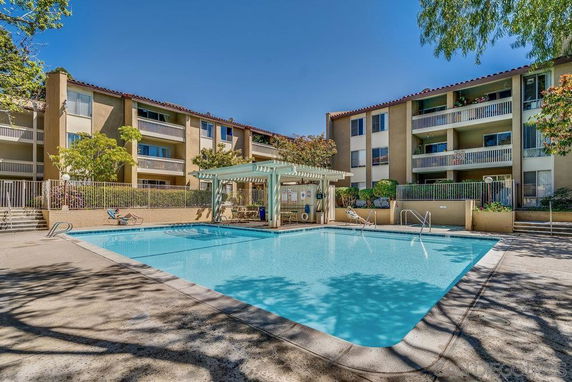 Outdoor swimming pool in front of a multi-story residential building.