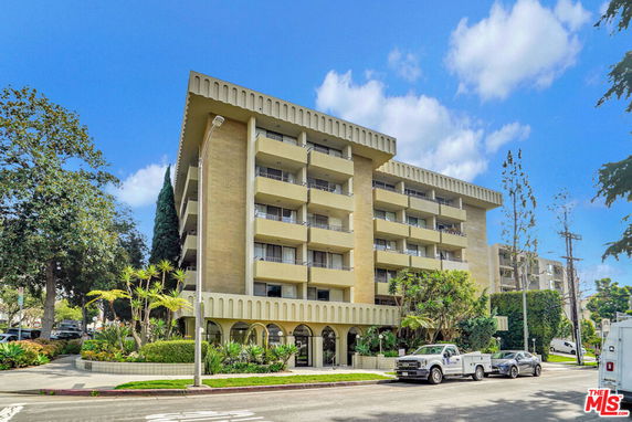 Front view of a multi-story apartment building with balconies.