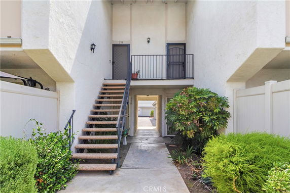 Front view of a building entrance with stairs leading to upper floor.