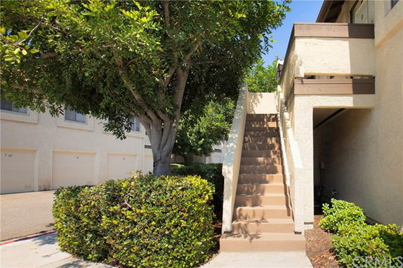 Front view of a building with exterior stairs leading up to a balcony.