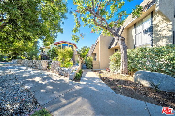 Front view of a house with a sloped roof and adjacent walkway.