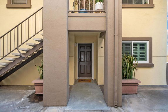 Entrance area of a building with a staircase on the side and a doorway.