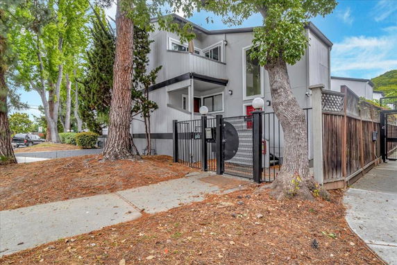 Front view of a modern two-story house with a gated entrance.
