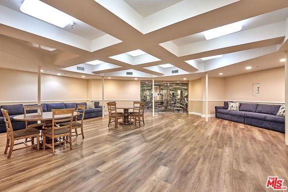 Interior view of a recreational room with seating and gym equipment.