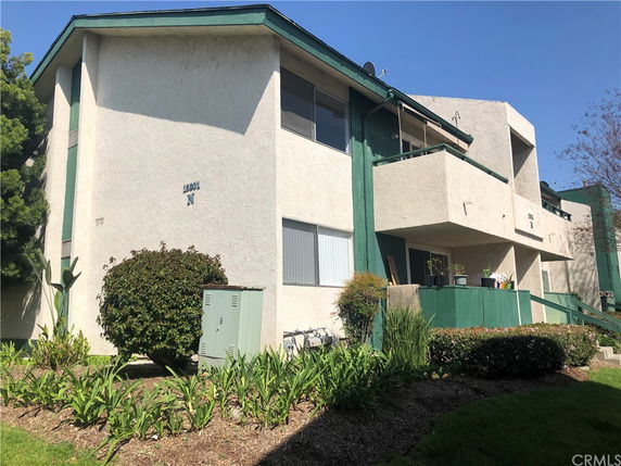 Front view of a two-story residential building with green and white exterior.