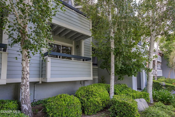 Front view of a multi-story residence with balconies and wooden siding.