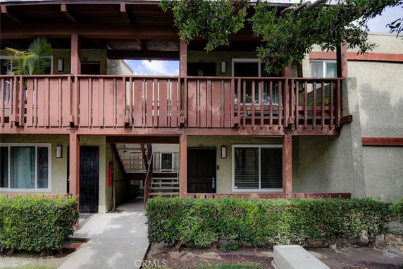 Front view of a two-story building with a wooden balcony.