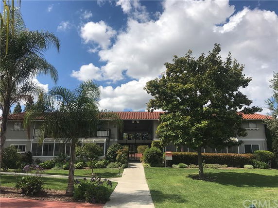 Front view of a two-story house with a red tile roof and a front walkway.