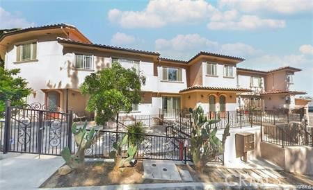 Front view of a two-story residential building with a gated entrance and balconies.