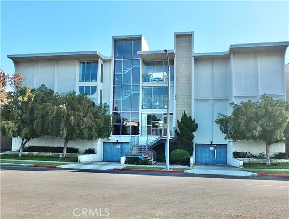 Front view of a multi-story building with large glass windows and exterior stairs.