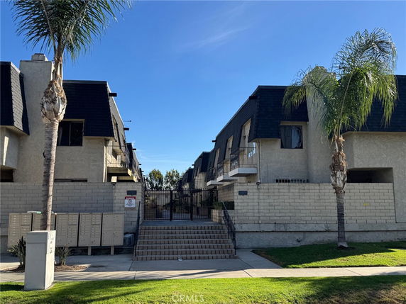 Front view of two-story apartment buildings with a gated entrance.