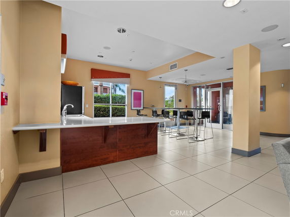 Recreational area with a counter and tables in a clubhouse setting.