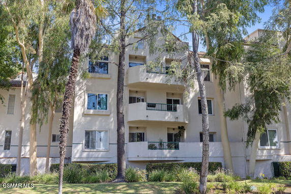 Front view of a multi-story apartment building with balconies.