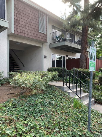 Front view of a two-story residential building with a small balcony and a staircase.