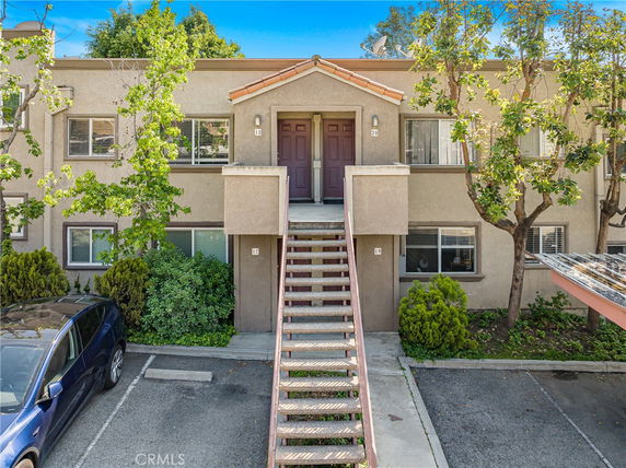 Front view of a two-story apartment building with stairway access.