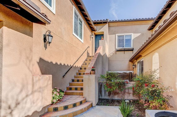 Front view of a house with exterior stairs leading to the entrance.