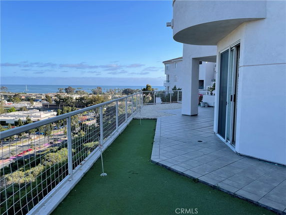 Panoramic view from a building showing surrounding areas and distant water body.