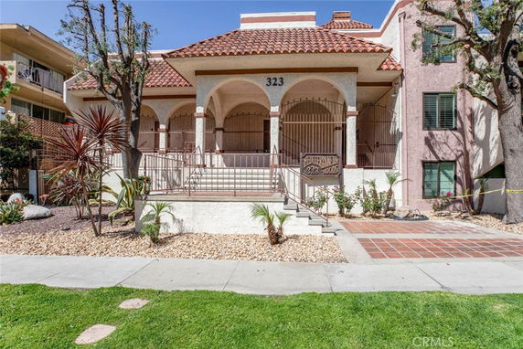 Front view of a building with Mediterranean-style architecture and arched entryway.