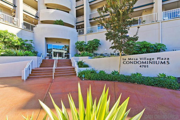 Front view of a condominium building with multiple balconies and entrance steps.