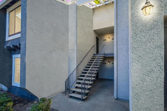 Entrance view of a building with outdoor staircase leading to the upper level.